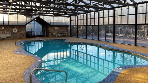 Ein Hallenbad mit freiem Blick nach draußen durch große Fenster.