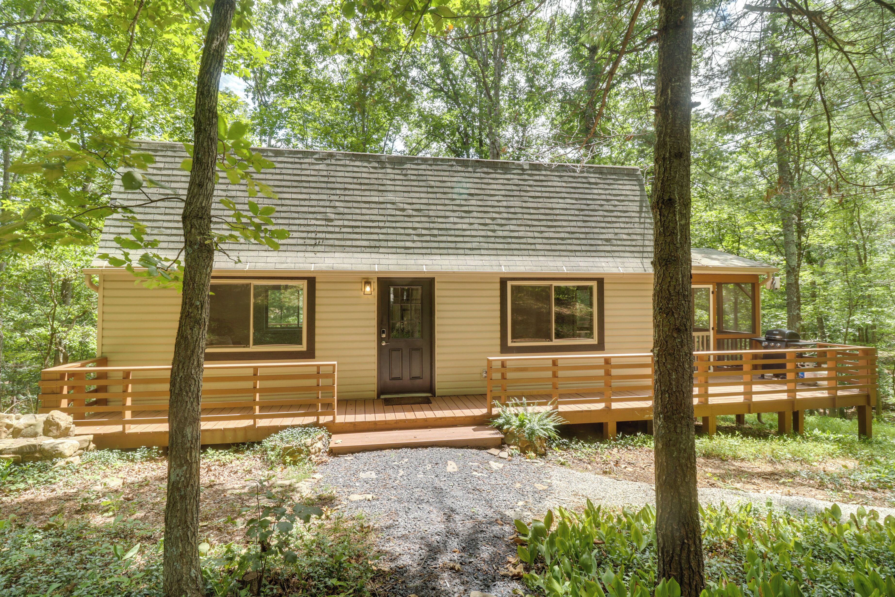 A cabin with a front porch, a door, and a small deck area.