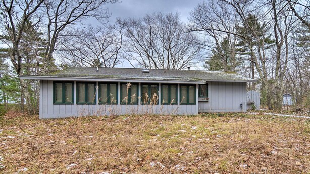 A single-story building with a flat roof, large windows, and a simple, unadorned exterior. - Idyllic Northport Cottage, Walk to Lakeside! (Northport)