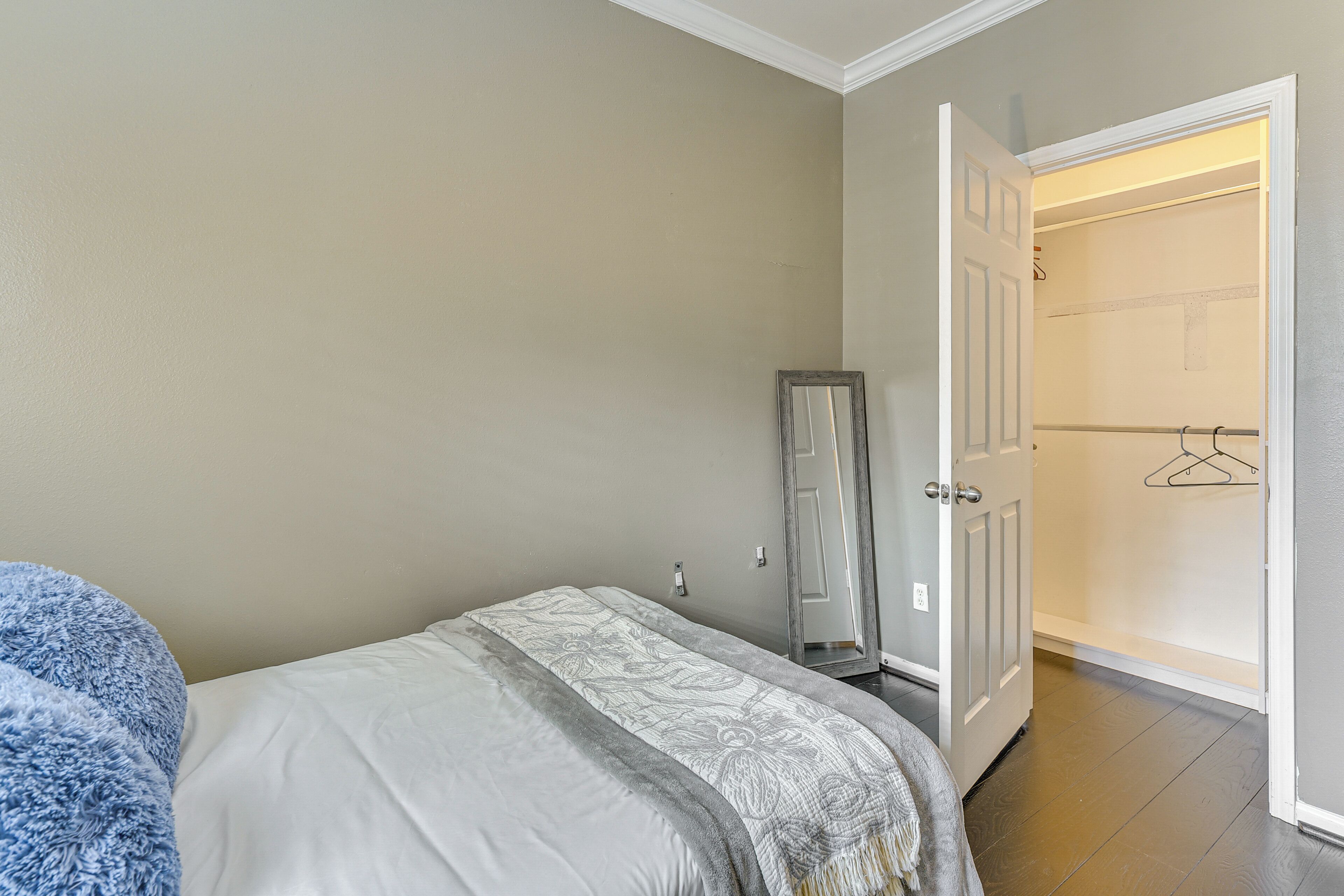 A bedroom with a bed, a wardrobe, and a door leading to a bathroom.