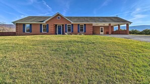 A single-story brick house with a front porch, a well-maintained lawn, and a clear blue sky. - Home w/ Hot Tub Near Shenandoah Nat'l Park! (Bentonville)