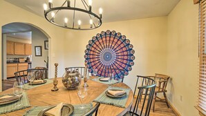 A dining area with a round table, chairs, a chandelier, and a decorative wall piece. - Home w/ Hot Tub Near Shenandoah Nat'l Park! (Bentonville)