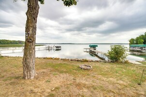 Vista con lago, muelles, un árbol y una zona con césped.