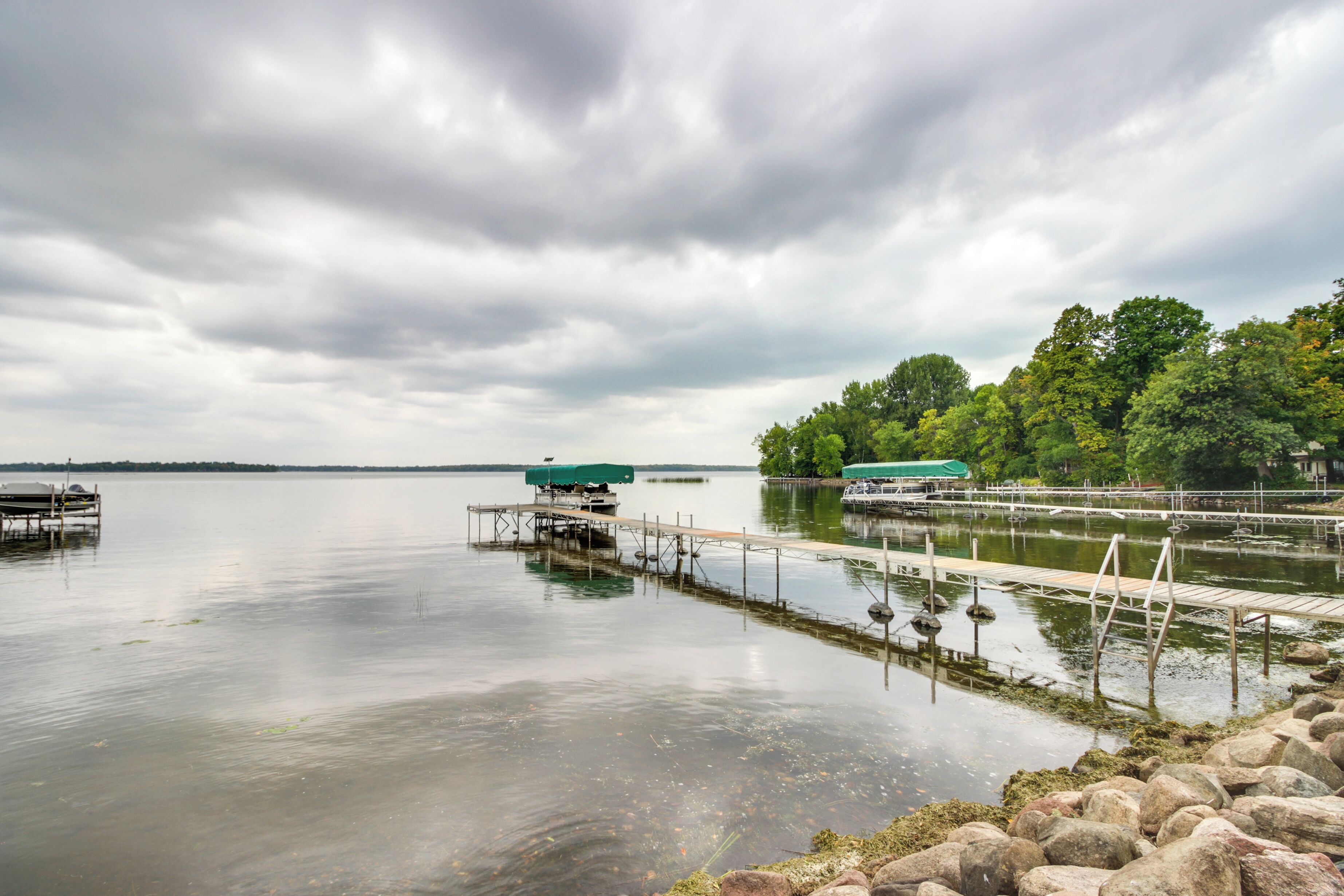 A calm lake with docks and boats.