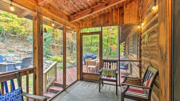 Une terrasse en bois avec des sièges extérieurs et une vue sur une zone boisée.