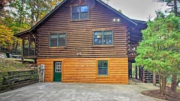Stunning log cabin with a central entrance and two windows, set amidst a serene natural backdrop.