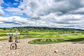 Kaunis maisema golfkentästä, jossa etualalla on puinen opastekyltti ja ruosteinen pyörä.