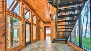 Un interior de madera con ventanas amplias, una escalera y vistas al exterior.