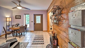 A dining area with a wooden table and chairs, a ceiling fan, and a fireplace with storage cabinets. - Steps to Beech Mountain Resort: Cozy Getaway (Banner Elk)