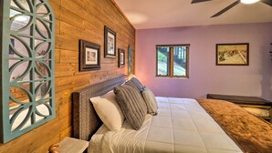 A bedroom with a wooden headboard, a bed with a quilt, a decorative wall panel, and framed pictures. - Steps to Beech Mountain Resort: Cozy Getaway (Banner Elk)