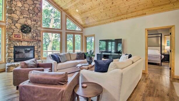 A spacious living room with a stone fireplace, large windows, and a cozy seating area. - Luxe Wintergreen Resort Escape w/ Hot Tub! (Nellysford)