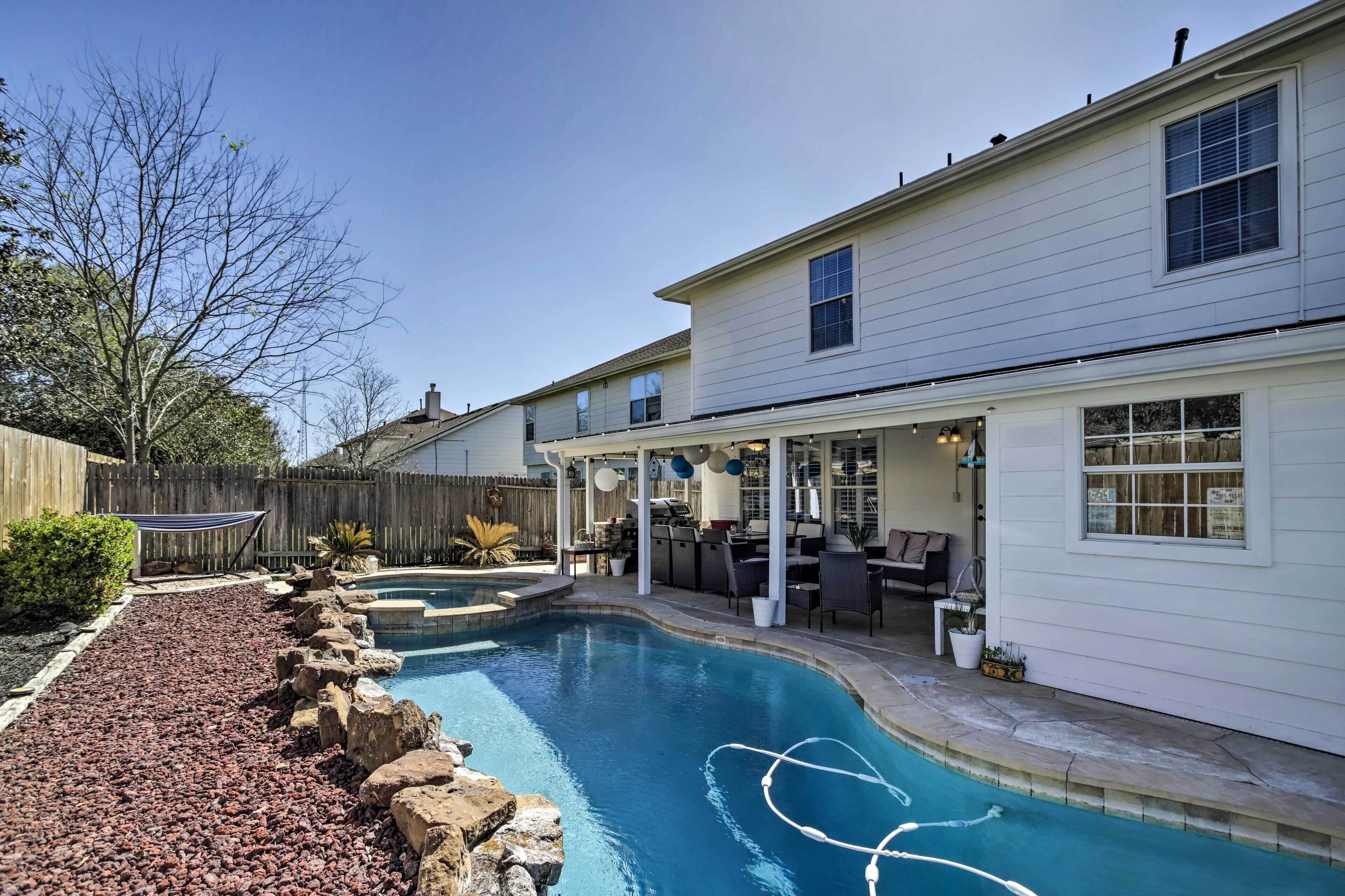 Un jardin avec une piscine, une terrasse en bois et un espace patio couvert.