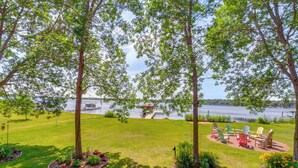 A grassy area with trees and a dock by a lake. - Large Home on Lake Edward w/ Deck & Fire Pit! (Nisswa)