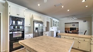 Una cocina moderna con armarios blancos, electrodomésticos de acero inoxidable y una isla grande.
