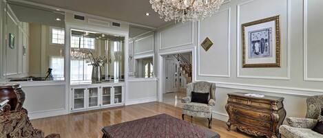 A spacious living room with a chandelier, a dining table, and a sofa.
