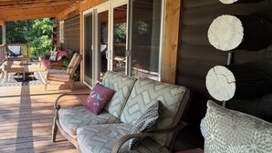 A wooden deck with a sofa and chairs, a covered area with a view of the outdoors, and a log wall. - Macungie Cabin w/ Fireplace Near Bear Creek Skiing (Macungie)