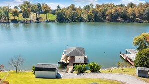 Une propriété située au bord d’un lac, comprenant un quai, un petit bâtiment et une zone herbeuse.