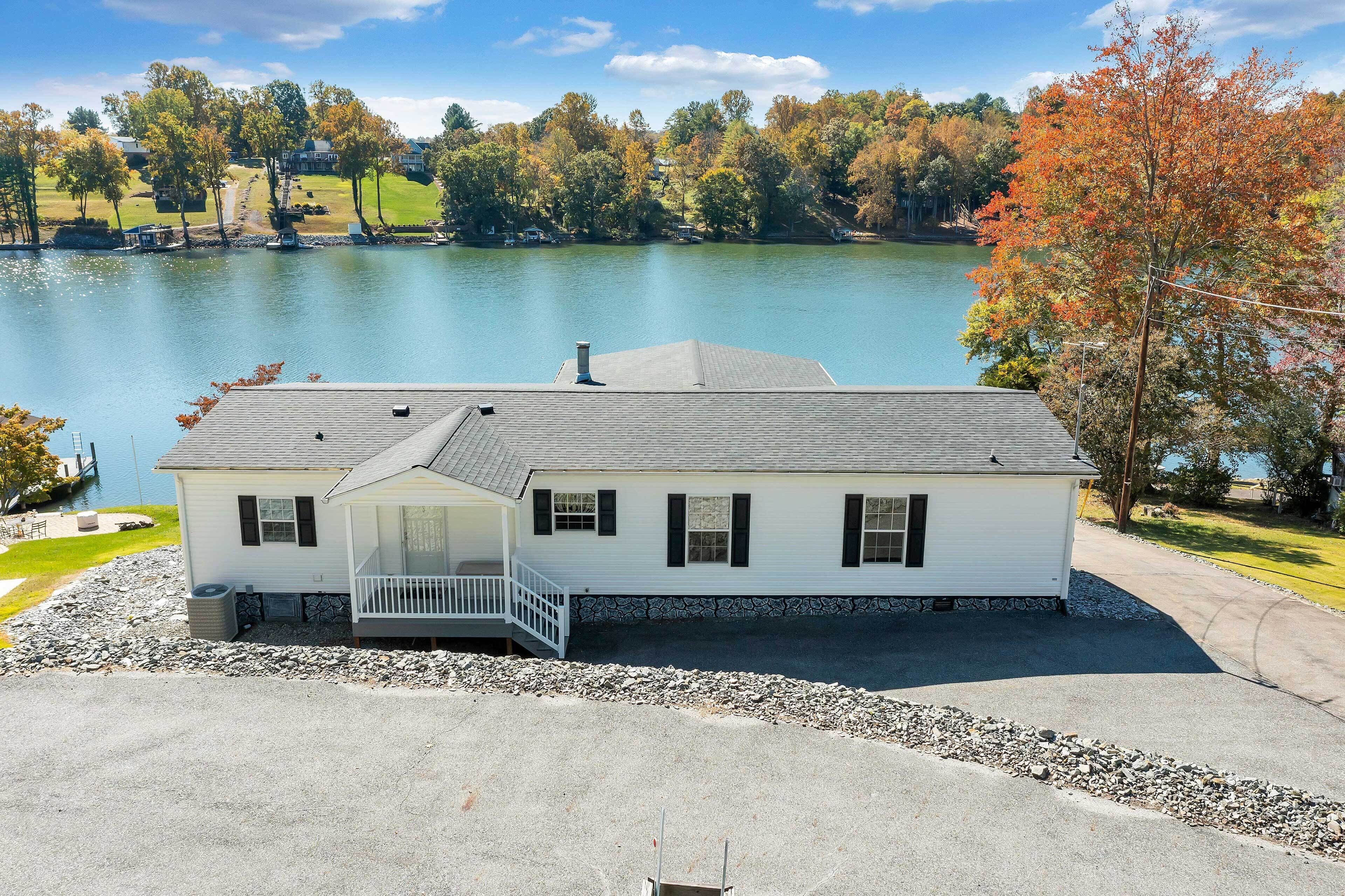 A white house with a porch and a view of a lake.