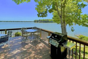 A deck with a grill, table, and chairs overlooking a lake. - Lakefront Grant Getaway w/ Deck + Fire Pit! (Grant)
