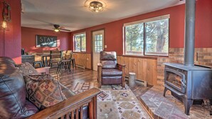 A cozy living room with a leather sofa, a fireplace, and a dining area with wooden furniture. - Divide Cabin in the Heart of Colorful Colorado! (Divide)