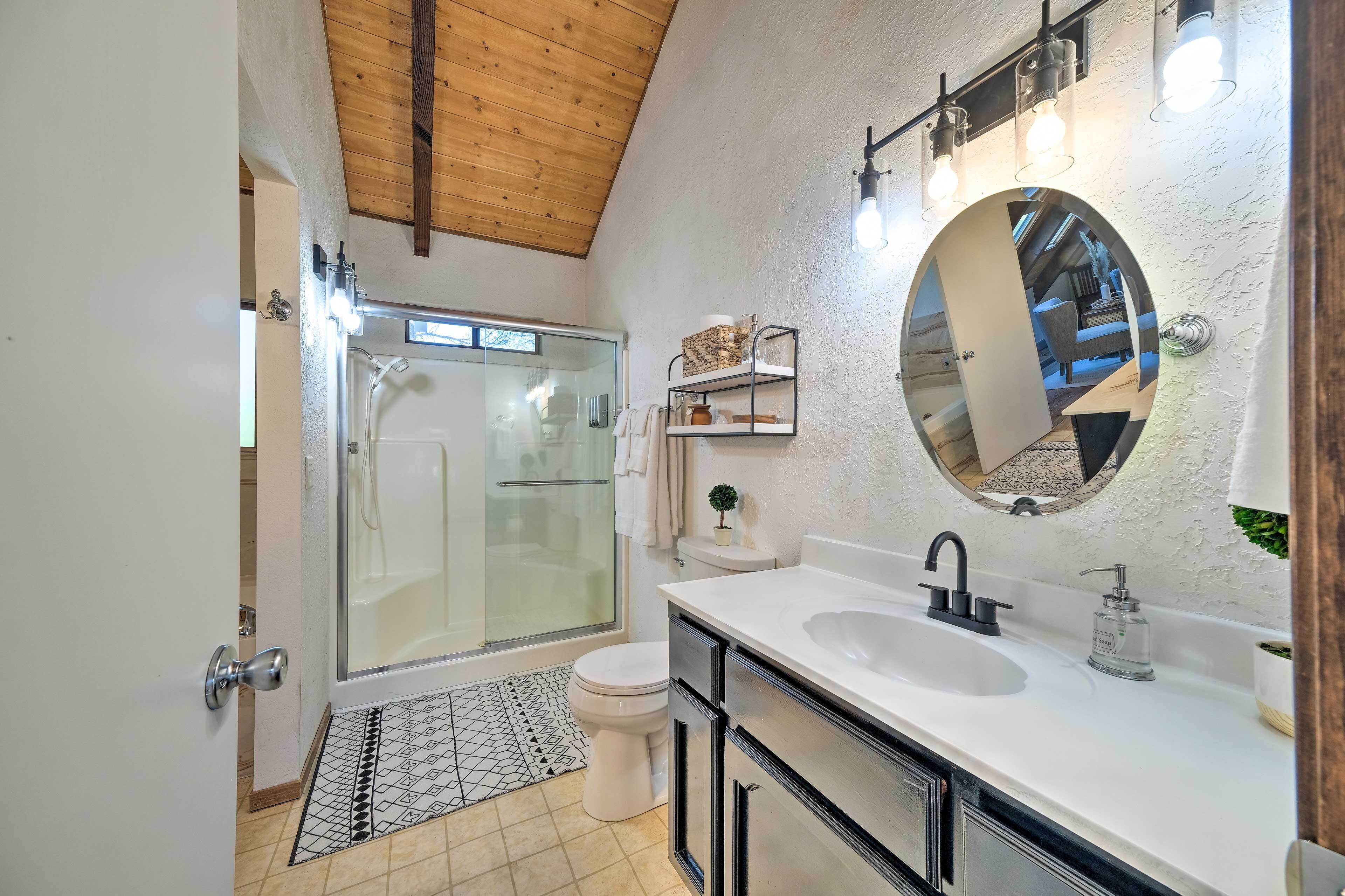 A modern bathroom with a shower, toilet, and sink.