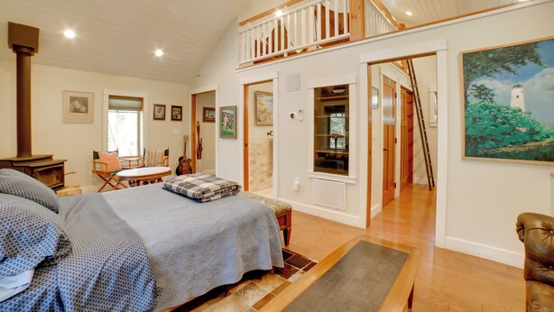 Ein geräumiges Schlafzimmer mit einem großen Bett, einer Holzbalkendecke und einem Balkon.