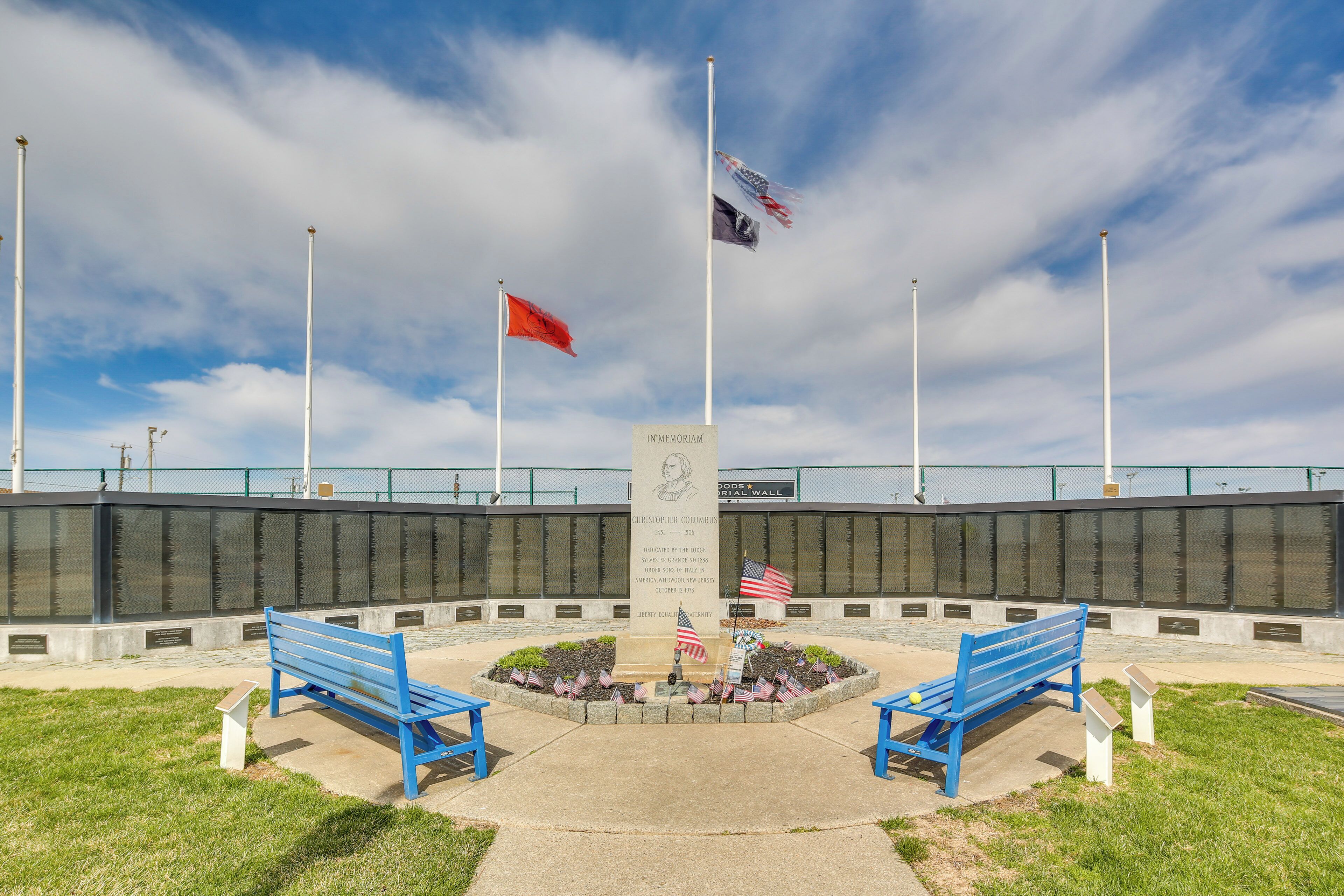 Un monumento con bancos, banderas y un memorial.