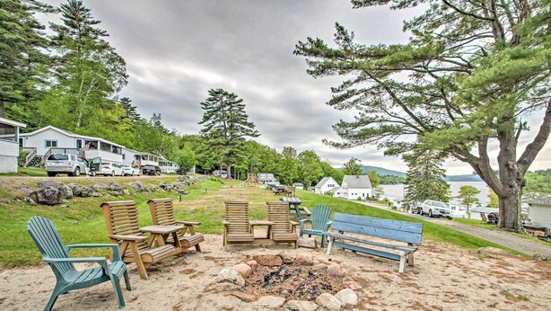 A beachside outdoor seating area with Adirondack chairs and a fire pit. - Newfound Lake Studio: Bbq, Fire Pit & Beach Access (Bristol)