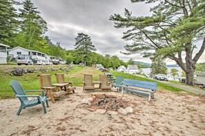 A beachside outdoor seating area with Adirondack chairs and a fire pit. - Newfound Lake Studio: Bbq, Fire Pit & Beach Access (Bristol)