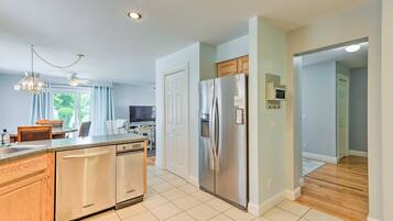 A modern kitchen with stainless steel appliances, a dishwasher, and wooden cabinets.