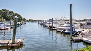 En lystbådehavn med både fortøjet langs et roligt vandløb, omgivet af grøn vegetation.