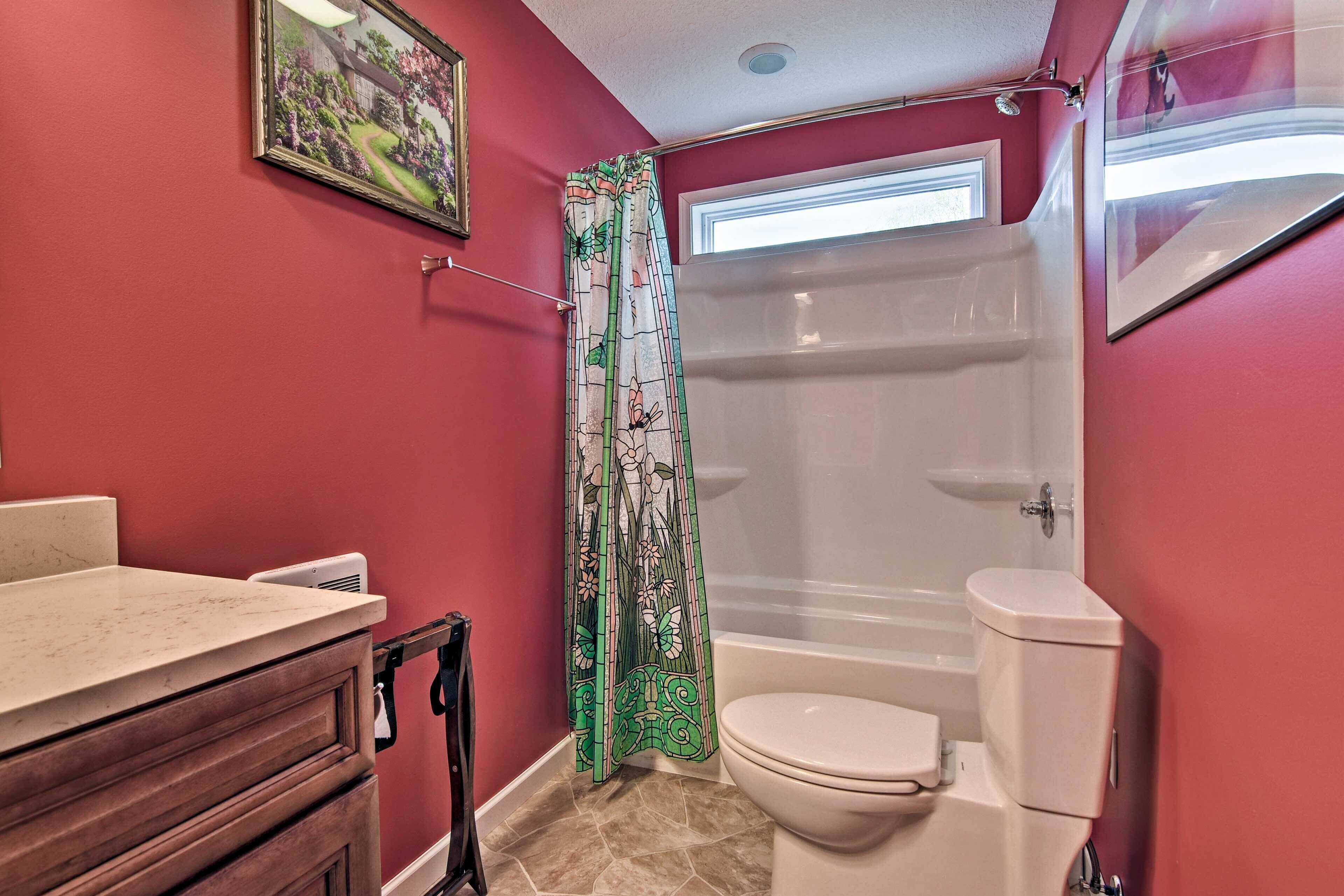 Een badkamer met een toilet, een douche en een wastafel.
