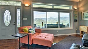 A living room with a large window, a cushioned seating area, and a small table. - Private Blue Ridge Home w/ Hot Tub, Mountain Views (Marshall)