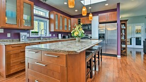 A modern kitchen with wooden cabinets, granite countertops, and pendant lighting. - Private Blue Ridge Home w/ Hot Tub, Mountain Views (Marshall)