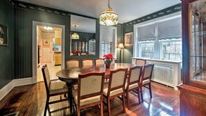 A dining room with a round table and six chairs, a chandelier, and a view of the outside through large windows. - Spacious Reading Home w/ Patio - 2 Miles to Pagoda (Reading)