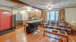 A compact living space with a kitchenette, a sofa, a coffee table, and a dining area. - Rustic Cottage With Fire Pit & Private Yard! (Fenwick)