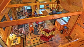 A spacious cabin interior with a loft bedroom, a dining area, and a cozy living room. - Rustic Dundee Log Cabin w/ Hot Tub & Forest Views! (Dundee)