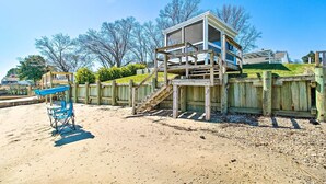 A beach house with a wooden deck and a covered outdoor seating area. - Refreshing Colonial Beach Vacation Rental! (Colonial Beach)