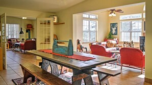 A spacious living room with a wooden dining table, red chairs, and a ceiling fan. - Quiet Ruidoso Hideaway - 2 Mi to Grindstone Lake! (Ruidoso)