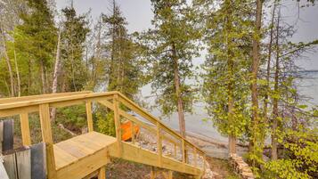 A wooden staircase leading to a beach area surrounded by trees.