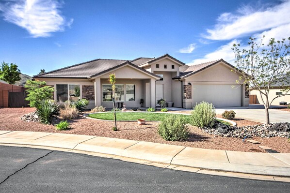 A two-story house with a garage, a well-maintained lawn, and a variety of landscaping including shrubs and a small tree. - Scenic La Verkin Home: 20 Mi to Zion National Park (La Verkin)