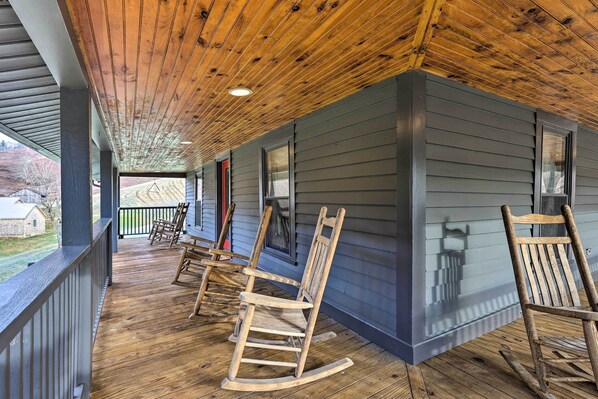 A porch with wooden rocking chairs and a view of the surrounding landscape. - Stylish Vilas Hideaway: Hike, Ski & Explore! (Vilas)