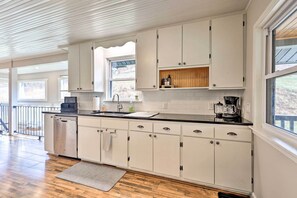 A modern kitchen with white cabinetry, a black countertop, and a built-in oven. - Stylish Vilas Hideaway: Hike, Ski & Explore! (Vilas)