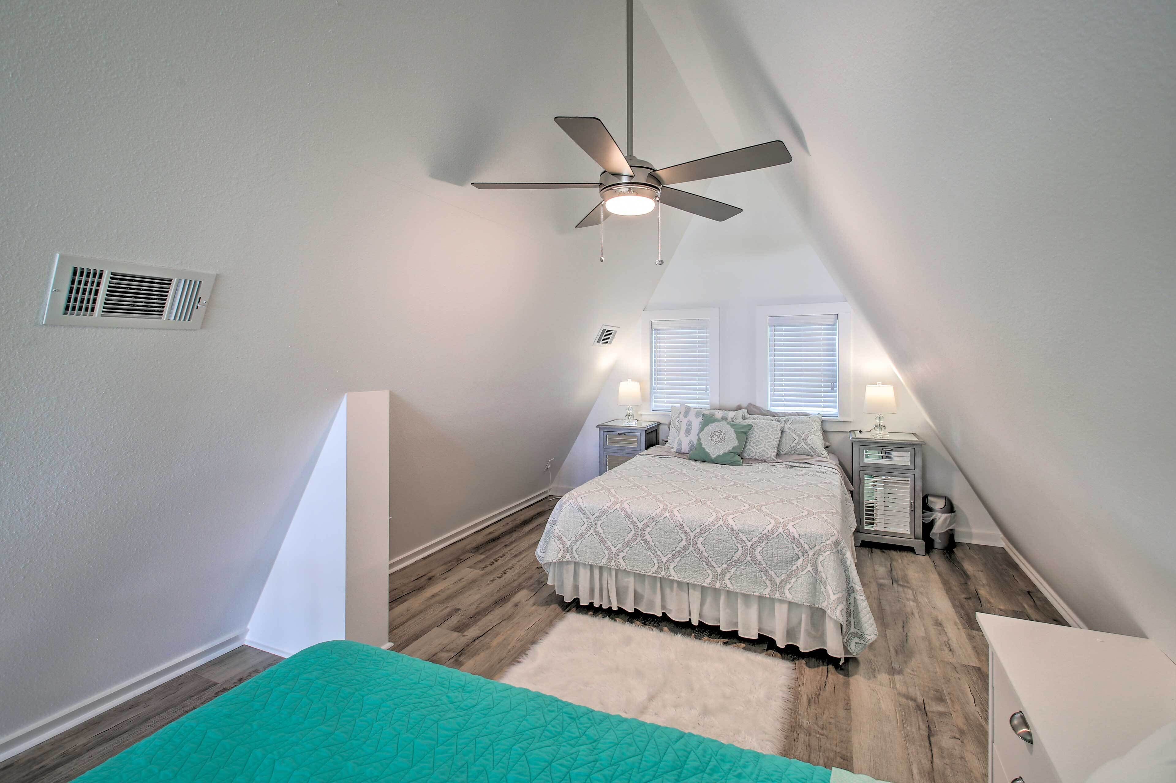 A bedroom with a bed, a ceiling fan, a heater, and a window with blinds.