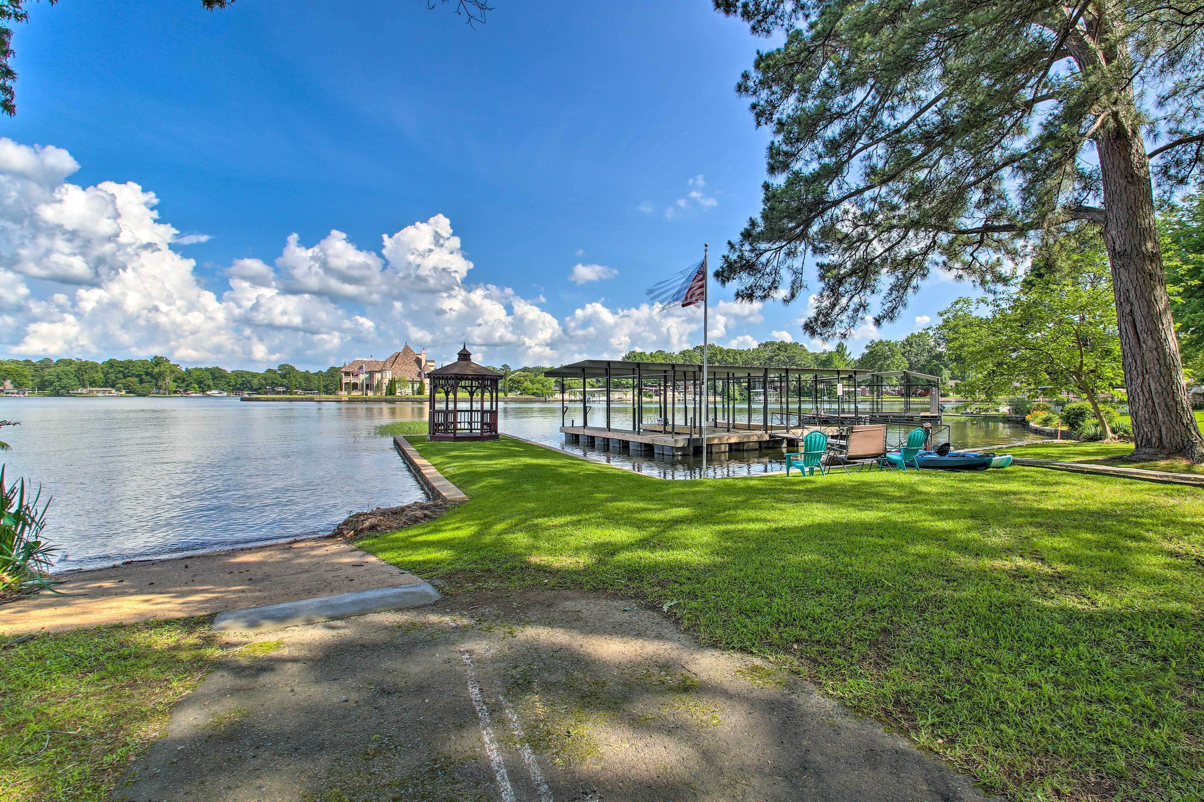 A lakeside gazebo, a covered dock, and a flagpole by the water.