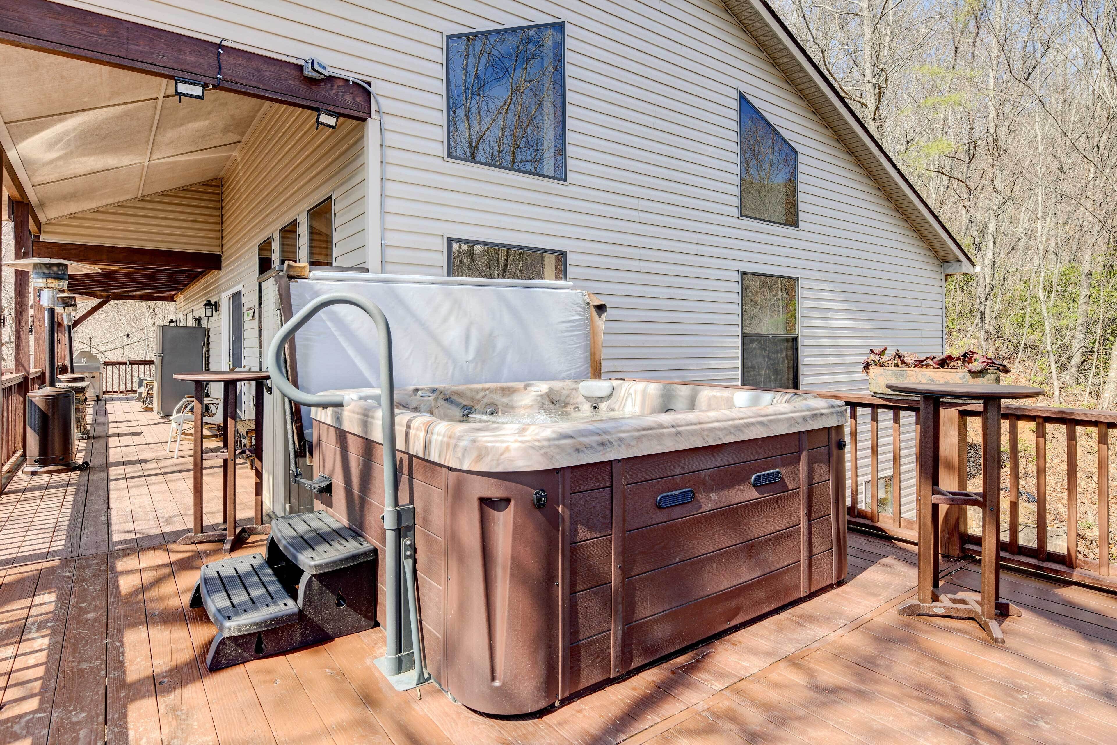 A hot tub on a wooden deck with a covered area and a house in the background.