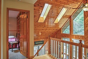 Ein Holzinnenraum mit Treppe, einem Bett und Blick ins Freie.