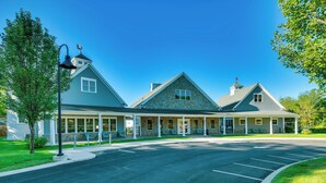 A two-story building with a stone facade, multiple windows, and a covered porch area. - Stylish Arundel Cottage, 6 Mi to Dock Square! (Kennebunkport)