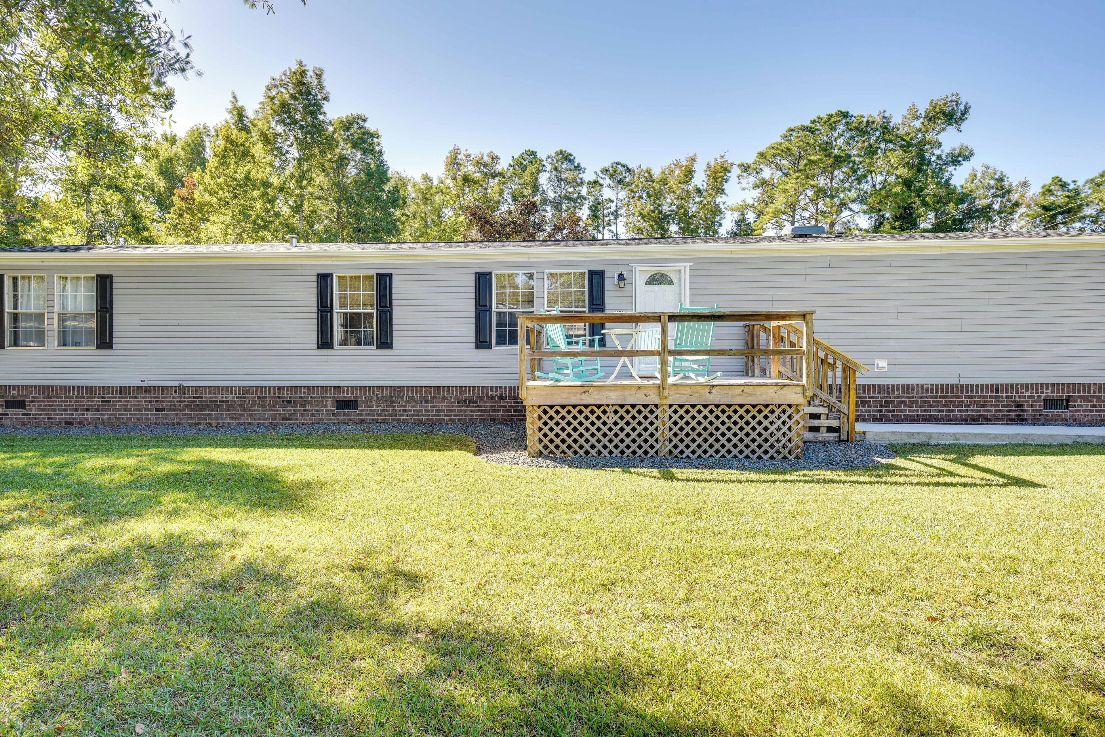 A mobile home with a deck and a fenced area.