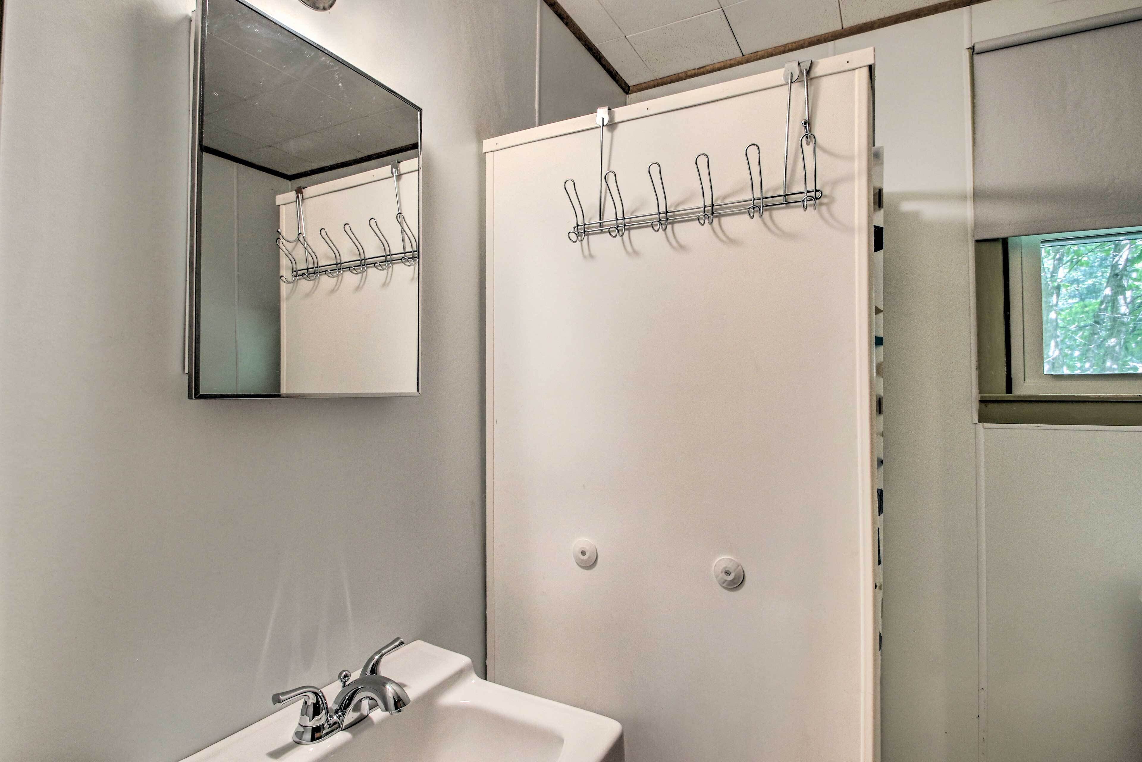 A bathroom with a white sink, a mirror, and a towel rack.